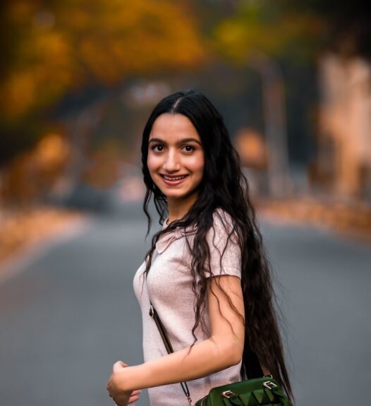 woman in white long sleeve shirt holding green sling bag